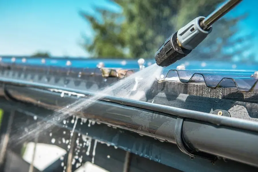 Clearing leaves from a clogged residential gutter
