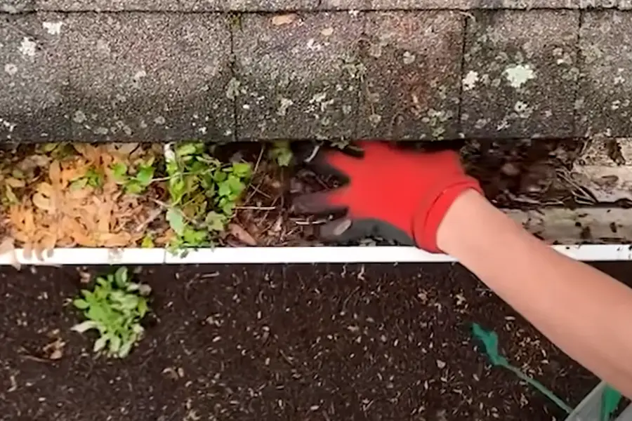 Rinsing a gutter after loose debris has been removed